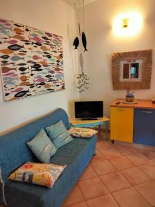 Villa Smeralda Costa Paradiso Sardinia holidays في كوستا باراديسو: غرفة معيشة مع أريكة زرقاء وتلفزيون