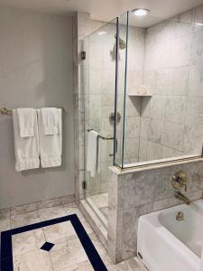 a bathroom with a shower and a bath tub at Market Pavilion Hotel in Charleston