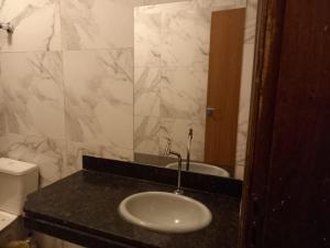 a bathroom with a sink and a mirror at casa grande e confortável in Pirapora +13 photos