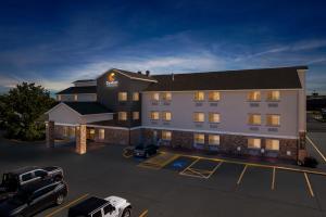 Un hotel con coches aparcados en un estacionamiento. en Comfort Inn & Suites Greeley, en Greeley
