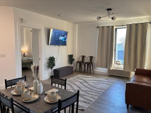 a living room with a table and chairs and a television at Sweet getaway 6 min from EWR in Elizabeth