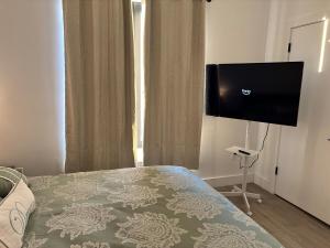 a bedroom with a bed and a flat screen tv at Sweet getaway 6 min from EWR in Elizabeth +5 photos