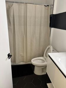 a bathroom with a toilet and a shower curtain at Sweet getaway 6 min from EWR in Elizabeth
