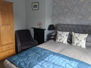 ein Schlafzimmer mit einem Bett und einem Stuhl in der Unterkunft 1 Hillside Cottages in Leeds + 13 Fotos