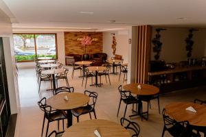 a restaurant with tables and chairs in a room at Hotel Marion ALVORADA in Campo Novo do Parecis