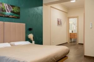 a bedroom with a bed and a green wall at RUSS0 ROOMs in Catanzaro