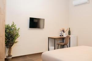 a room with a table and a tv on a wall at RUSS0 ROOMs in Catanzaro