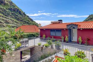 a house with a balcony with a mountain at Casa da Praia, a Home in Madeira in Ribeira Brava