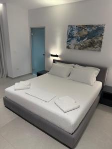 a bedroom with a large bed with white sheets and pillows at Adele Hotel Ksamil in Ksamil