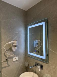 a bathroom with a mirror and a toilet at Adele Hotel Ksamil in Ksamil