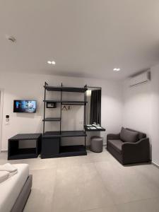 a living room with a couch and a tv at Adele Hotel Ksamil in Ksamil