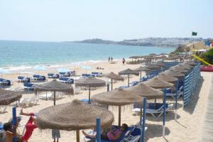 a beach with many umbrellas and people on the beach at Forte Apartment in Albufeira