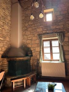 a living room with a fireplace and a window at Saint George Apartments II & III in Kalavrita