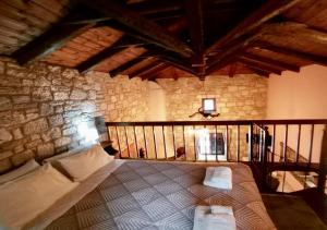 a bedroom with a bed in a stone wall at Saint George Apartments II & III in Kalavrita