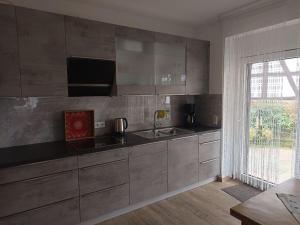 a kitchen with stainless steel appliances and a large window at Im Hochparterre relaxen in Breitenbach am Herzberg +16 photos