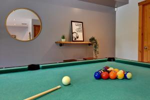 ein Billardzimmer mit einem Billardtisch mit Bällen in der Unterkunft Chic Familiale, Relaxant avec spa en montagnes in Labelle