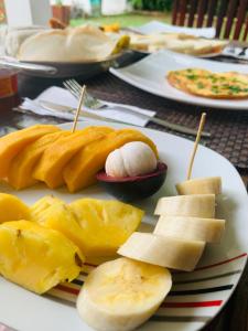 a plate of food with fruit on a table at Chill House Udawalawa in Udawalawe +18 photos