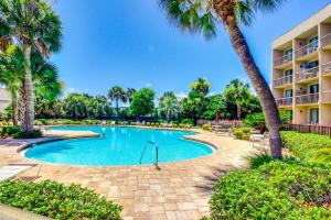 una piscina con palmeras en un resort en Pirates Bay A304, en Fort Walton Beach