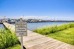 Un cartel delante de un puerto deportivo con un muelle en Pirates Bay A304, en Fort Walton Beach