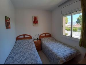 ein Schlafzimmer mit zwei Betten und einem Fenster in der Unterkunft Villa Naomi in Les tres Cales