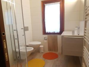 a bathroom with a toilet and a sink and a window at DOLOMITI Ferienwohnung, Appartamento vacanze. in San Pietro di Cadore +34 photos
