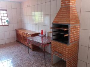a brick oven in a kitchen with a table at Chácara Escobar in Olímpia