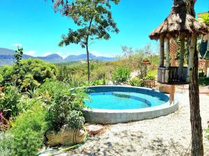 a small pool in a garden with a gazebo at Casa Terras Altas in Ibicoara