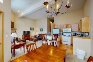 a kitchen and living room with a table and chairs at Wildernest Gore Trail Condo in Silverthorne