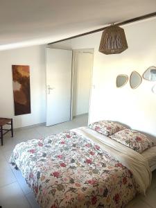 a bedroom with a bed with a floral bedspread at Terracotta Nougat in Montélimar