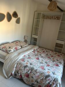 a bedroom with a bed with a floral bedspread at Terracotta Nougat in Montélimar +12 photos