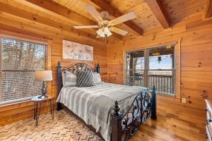 Un dormitorio con una cama y un ventilador de techo. en Above and Beyond, Cabin with Massive Views Near Helen, en Cleveland