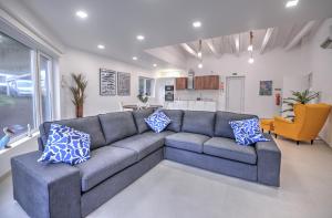 a living room with a gray couch and blue pillows at Flores Whale Watch House in Faja Grande