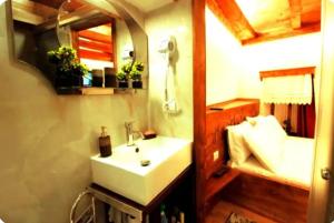 a bathroom with a white sink and a bed at Ela's Chalet in Old Bazaar Gjirokaster in Gjirokastër +7 photos