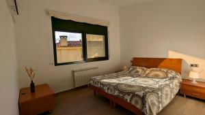 a bedroom with a bed and a window at Casa con piscina in Tossa de Mar +24 photos