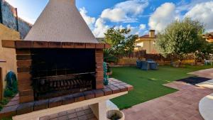a backyard with a brick fireplace in a yard at Casa con piscina in Tossa de Mar