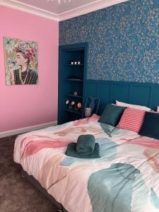 una camera da letto con un grande letto con un cappello sopra di The Gatehouse, 2 bedroom detached cottage a Beith