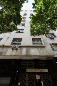 a tall building with windows and a sign for a store at Quarto&Sala Completo a 300m da Praia | NSC 386/402 in Rio de Janeiro