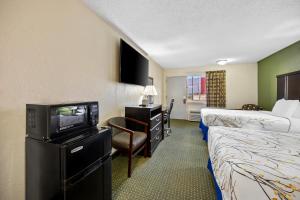 a hotel room with two beds and a television at America's Best Value Inn-Columbia in Columbia