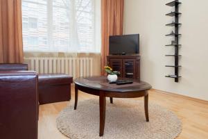 a living room with a coffee table and a tv at Old Town Apartments in Vilnius