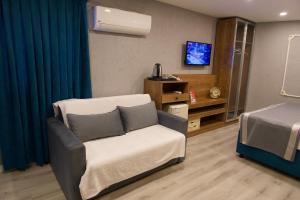 a room with a chair and a bed and a television at Hotel Mara İstanbul in Istanbul