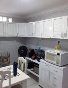 a kitchen with white cabinets and a microwave at Casa ampla Olinda in Olinda +6 photos