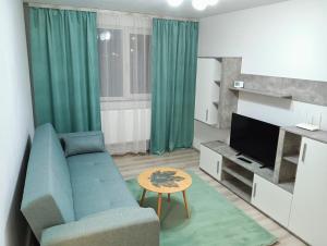 a living room with a blue couch and a tv at Apartament HD2 in Hunedoara