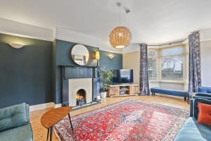 a living room with a fireplace and a couch at Wyndgrove House - North East Escapes in Seahouses