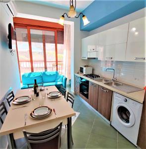 eine Küche und ein Esszimmer mit Tisch und Stühlen in der Unterkunft Appartamento sul lungomare di Castellabate per 4 persone in Santa Maria di Castellabate