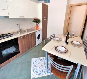 eine Küche mit Tisch und Spüle in der Unterkunft Appartamento sul lungomare di Castellabate per 4 persone in Santa Maria di Castellabate + 10 Fotos