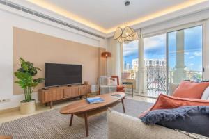 ベイルートにあるMundo - Exquisite 2-BR W Balcony at Saifi Villageの薄型テレビとソファのあるリビングルーム