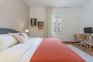 ベイルートにあるMundo - Exquisite 2-BR W Balcony at Saifi Villageの大きなベッドとコンピューター付きの机がある寝室