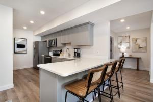 a kitchen with a white counter top and chairs at Cedar Peak Condo - Downtown Sevierville in Sevierville