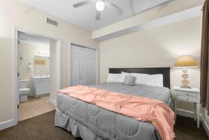 a bedroom with a bed and a bathroom at 20th-floor condo with Gulf views, resort amenities & 2 lagoon-style pools in Panama City Beach