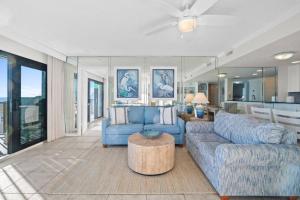a living room with blue couches and a table at Commodore 410 in Panama City Beach